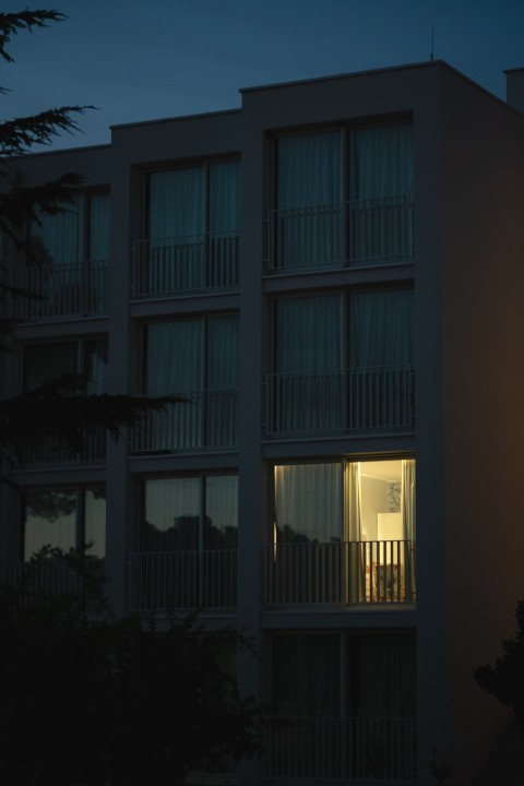 Vertical shot of a modern white building with light coming out f